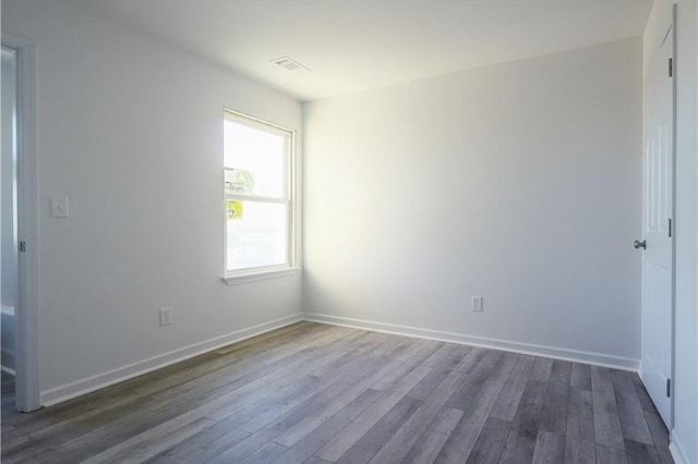 empty room featuring dark wood-type flooring and baseboards