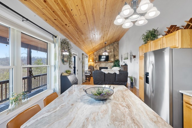 dining space with wood finished floors, an inviting chandelier, a fireplace, lofted ceiling, and wood ceiling