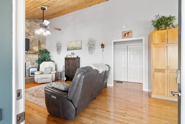 living room featuring baseboards, high vaulted ceiling, ceiling fan, light wood-style floors, and wooden ceiling