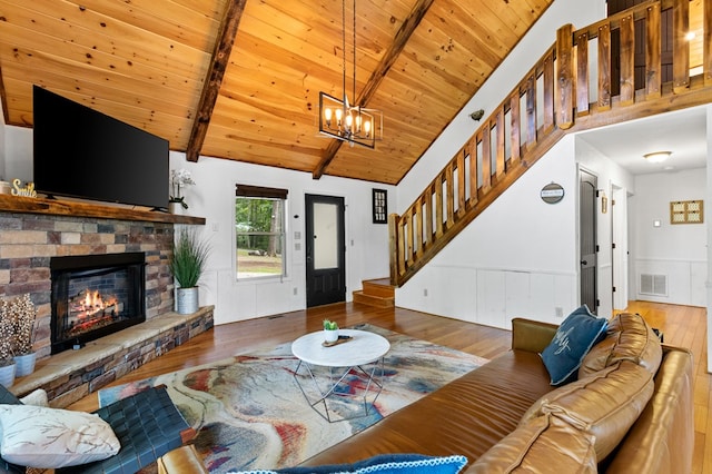 living room featuring hardwood / wood-style floors, wooden ceiling, vaulted ceiling with beams, a fireplace, and a chandelier