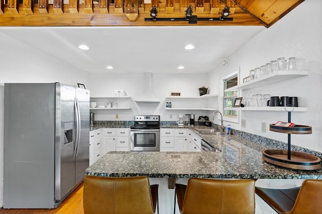 kitchen featuring a kitchen breakfast bar, sink, custom range hood, kitchen peninsula, and stainless steel appliances