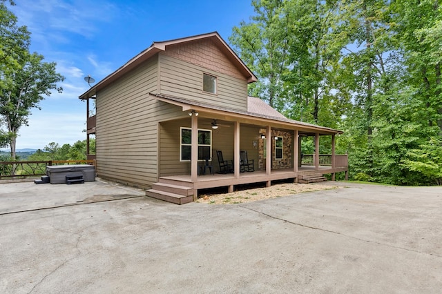 exterior space with ceiling fan, a wooden deck, and a hot tub