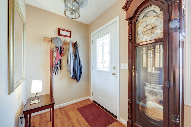 foyer with light wood-type flooring and a textured ceiling