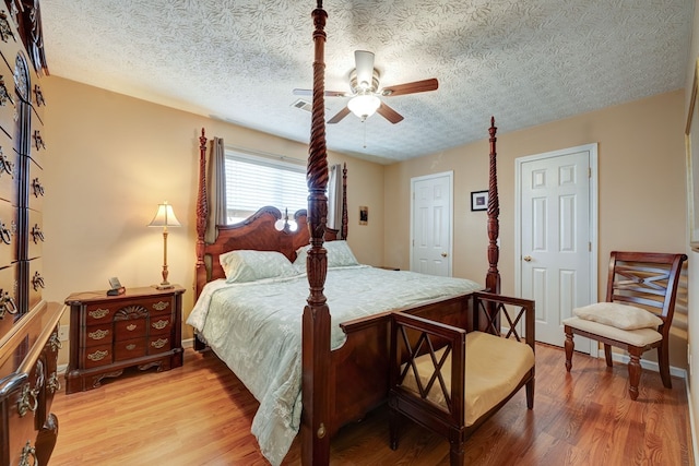 bedroom with ceiling fan, a textured ceiling, and hardwood / wood-style floors