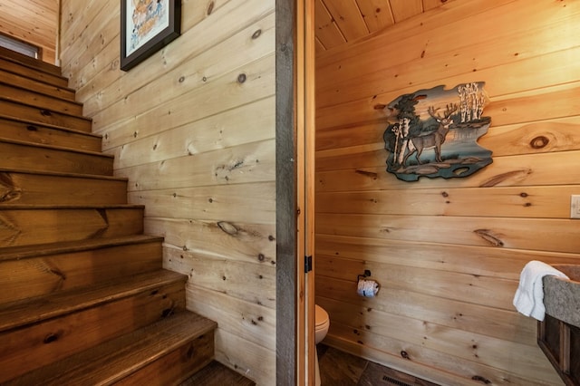 stairs featuring wood walls and wood ceiling