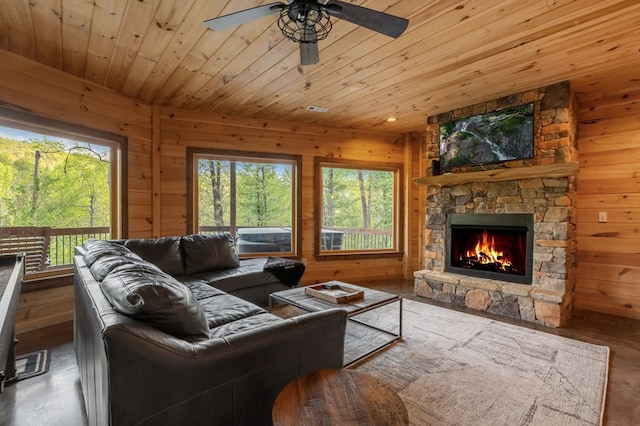 living room with a fireplace, wood-type flooring, wooden walls, and ceiling fan