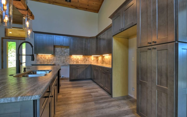 kitchen with tasteful backsplash, wood-type flooring, sink, hanging light fixtures, and wooden ceiling