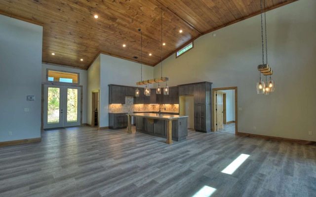 kitchen with a center island with sink, decorative light fixtures, high vaulted ceiling, and wooden ceiling