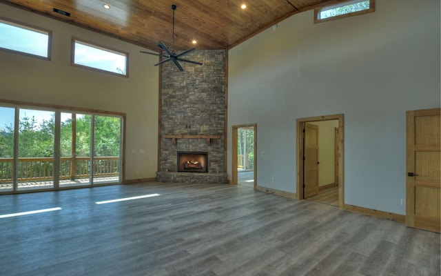 unfurnished living room featuring a healthy amount of sunlight, high vaulted ceiling, wooden ceiling, and a fireplace