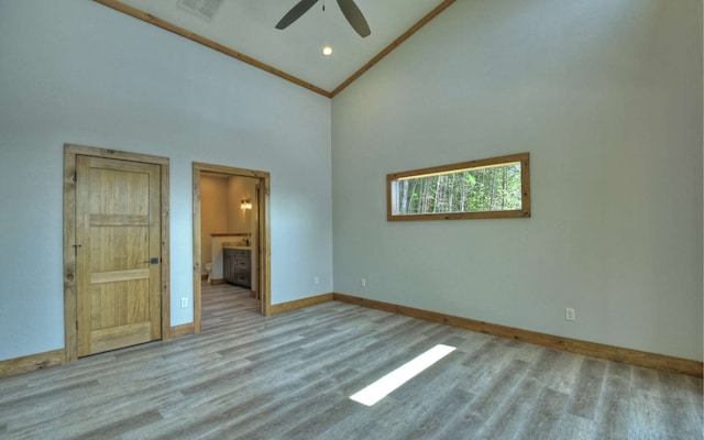 spare room with light wood-type flooring, high vaulted ceiling, and ceiling fan