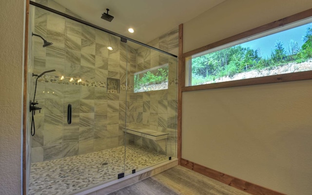 bathroom with hardwood / wood-style floors and a shower with shower door