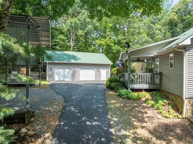 detached garage featuring covered porch and a ceiling fan