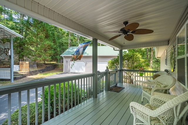 wooden deck with a ceiling fan and an outbuilding