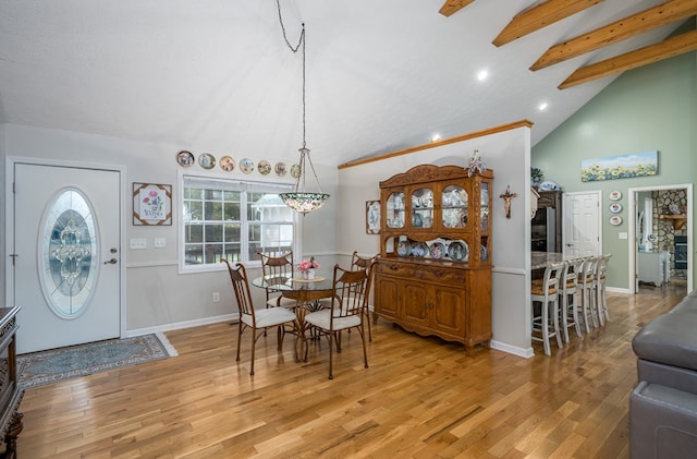 dining room featuring baseboards, beamed ceiling, and light wood-style floors