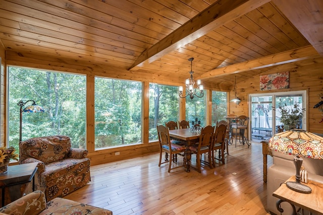 dining area featuring vaulted ceiling with beams, light wood finished floors, wooden ceiling, and a chandelier