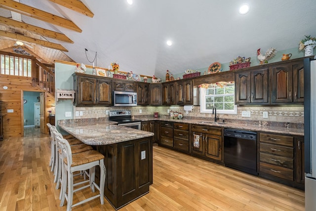 kitchen featuring backsplash, appliances with stainless steel finishes, a sink, dark brown cabinetry, and a peninsula