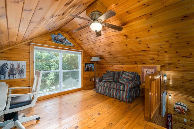 interior space with a ceiling fan, hardwood / wood-style flooring, wood ceiling, vaulted ceiling, and wood walls