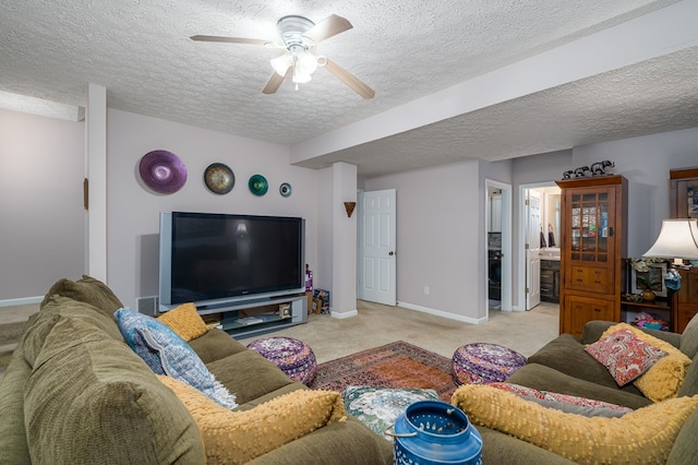 living room with a textured ceiling, carpet floors, ceiling fan, and baseboards