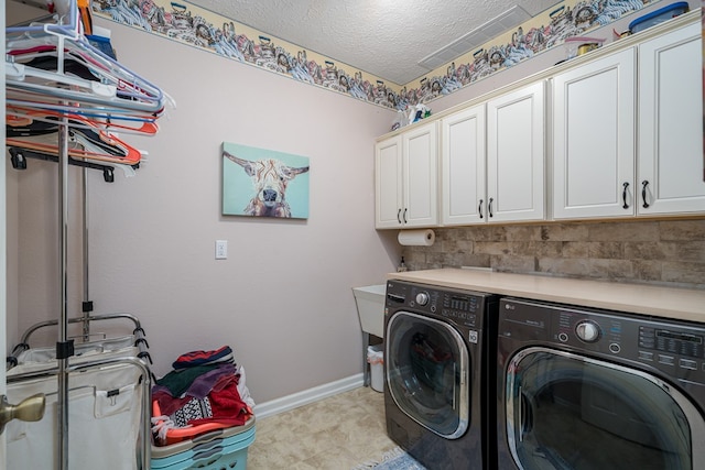 laundry room featuring cabinet space, independent washer and dryer, a textured ceiling, and baseboards