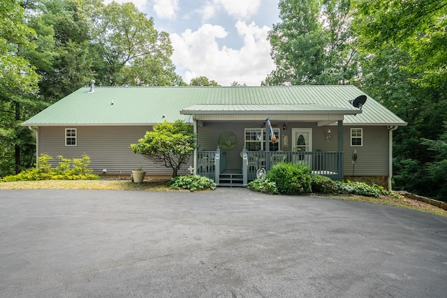 single story home with covered porch and metal roof