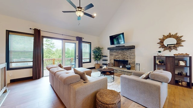 162 Barefoot Trl, Blairsville, GA 30512 - living room featuring high vaulted ceiling, a ceiling fan, a stone fireplace, light wood-type flooring, and baseboards