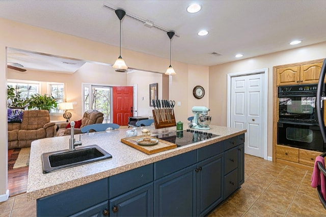 kitchen featuring a sink, light countertops, black appliances, open floor plan, and recessed lighting