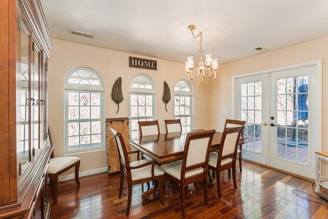 dining room featuring visible vents, a chandelier, french doors, and dark wood finished floors