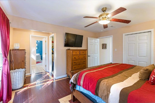 bedroom with hardwood / wood-style flooring, visible vents, ceiling fan, baseboards, and a closet