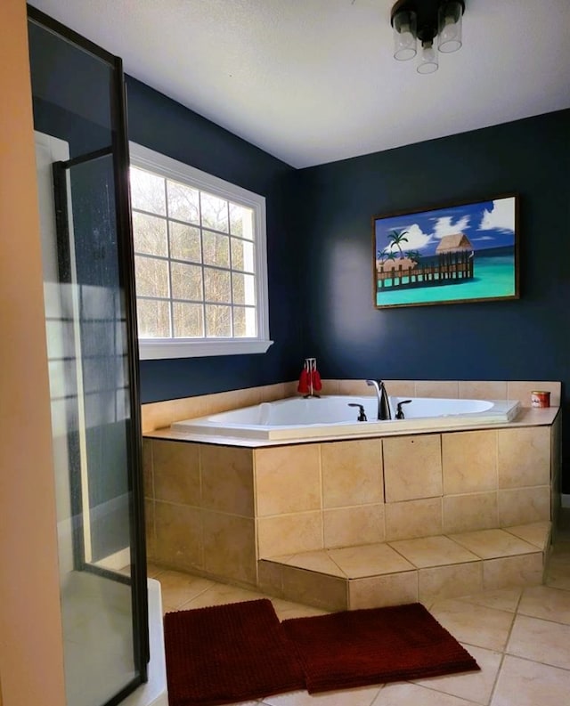 full bathroom featuring a bath, tile patterned flooring, and a shower stall