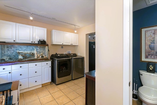 laundry area with track lighting, light tile patterned flooring, independent washer and dryer, and cabinet space
