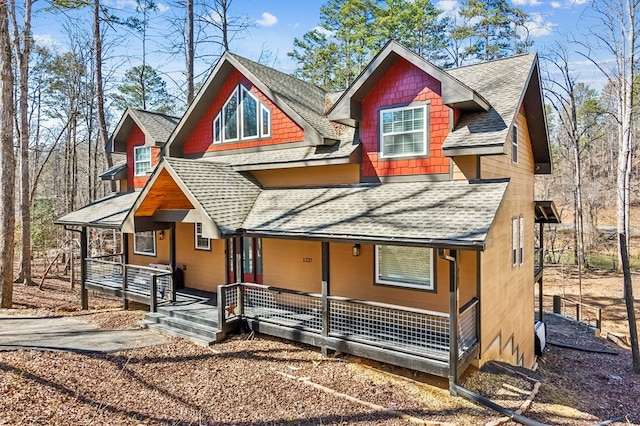 rustic home featuring a shingled roof and a porch