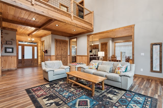 living area with wainscoting, wooden ceiling, wood finished floors, beamed ceiling, and recessed lighting