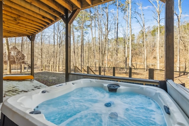 exterior space featuring a forest view and a hot tub