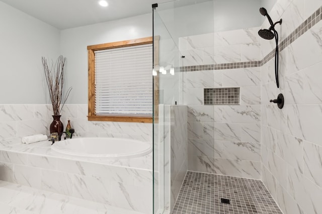 bathroom with a garden tub and a tile shower