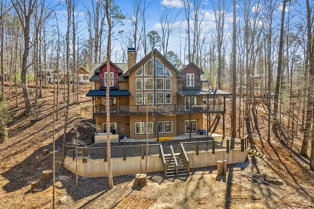 back of property with stairs and a chimney