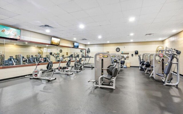 exercise room with a paneled ceiling and visible vents