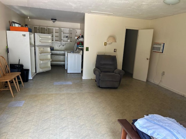 sitting room featuring tile patterned floors and an AC wall unit