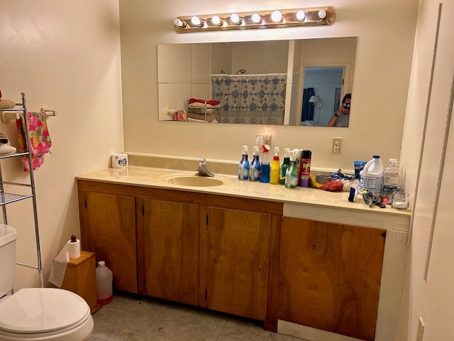 bathroom with vanity, tile patterned flooring, and toilet