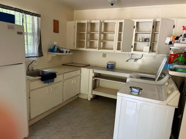 kitchen featuring sink, white fridge, white cabinets, and tile patterned flooring