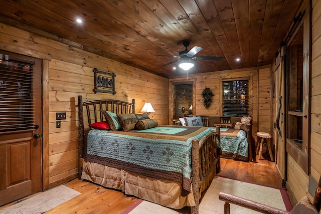 bedroom with wood ceiling, light wood-style flooring, and wooden walls