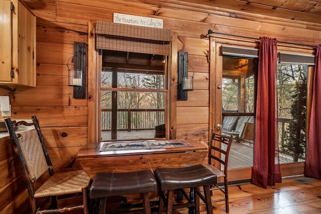 dining room featuring wooden walls and wood finished floors