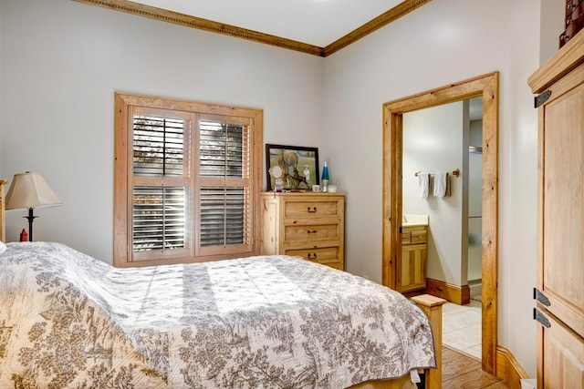 bedroom with connected bathroom, baseboards, and ornamental molding