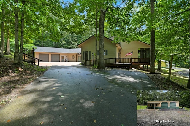 view of side of home with driveway, a wooden deck, and a garage