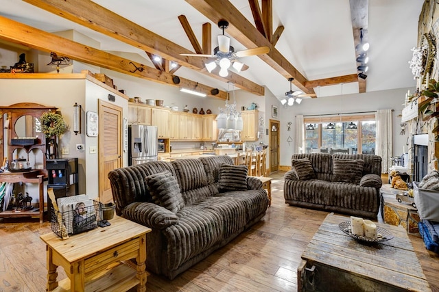 living area with a ceiling fan, high vaulted ceiling, beam ceiling, and light wood finished floors
