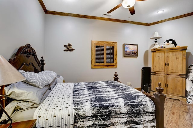 bedroom with crown molding, a ceiling fan, visible vents, and light wood-style flooring