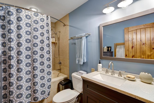 bathroom featuring toilet, shower / bath combo with shower curtain, and vanity