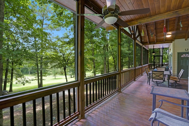 sunroom / solarium with beamed ceiling, a ceiling fan, and outdoor dining area