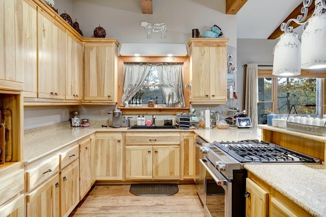 kitchen with light wood-type flooring, a sink, light brown cabinetry, and gas range