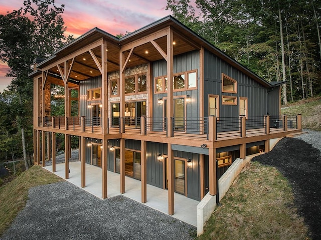 back house at dusk featuring a patio area and a balcony