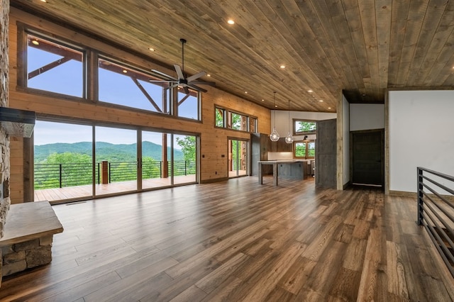 unfurnished living room featuring wood ceiling, ceiling fan, a mountain view, a high ceiling, and dark hardwood / wood-style floors